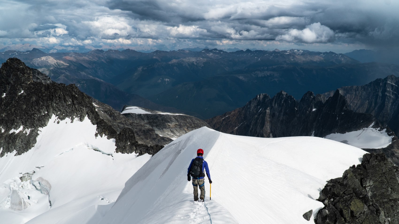 alpinist carefully walking on snow ridge on rogers peak