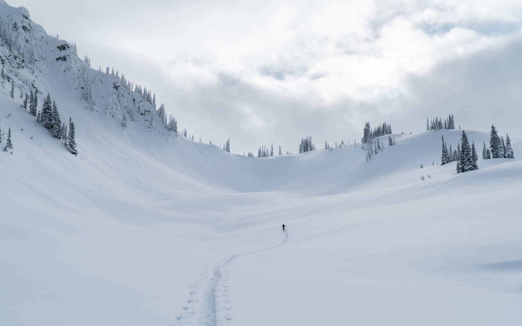 man ski touring in an open bowl at the foot of ghost peak