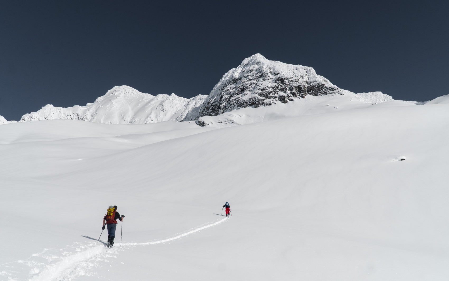 two mountaineers skiing up towards avalanche mountain