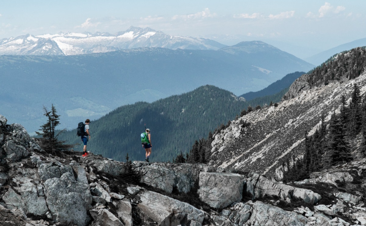 two hikers walking along the mt williamson north ridge on the revelstoke to sale mountain traverse