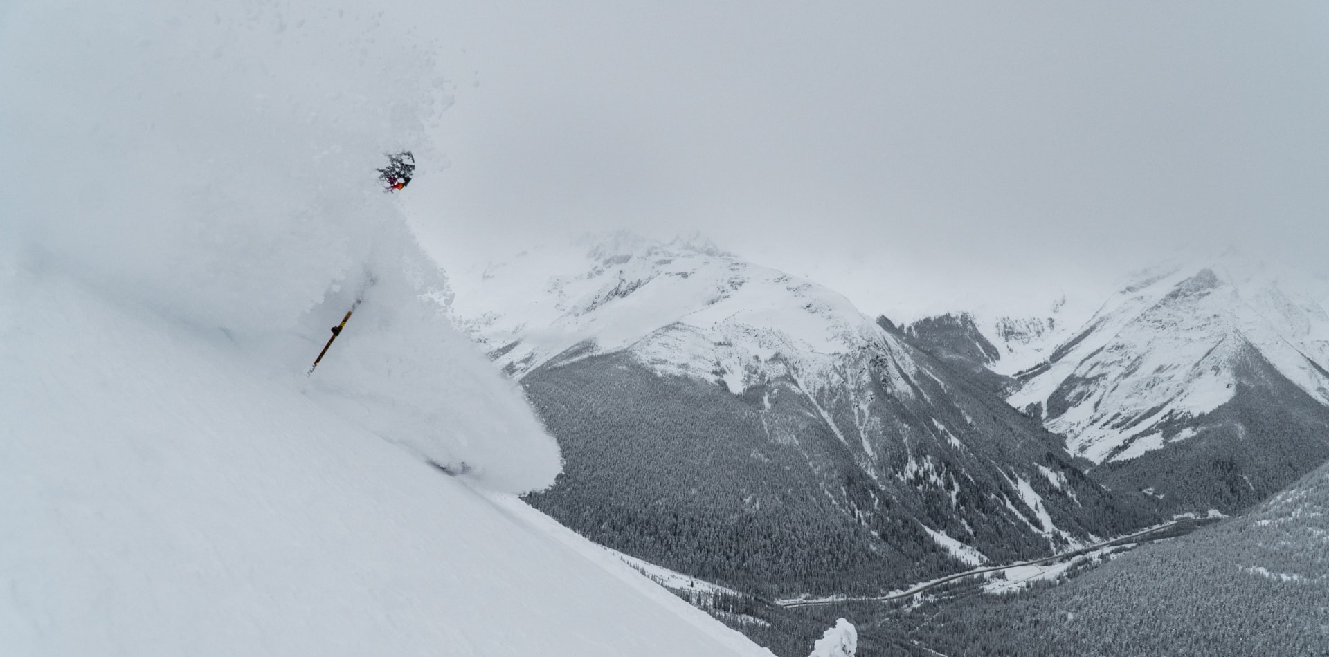skier bursting through a cloud of powder snow in rogers pass