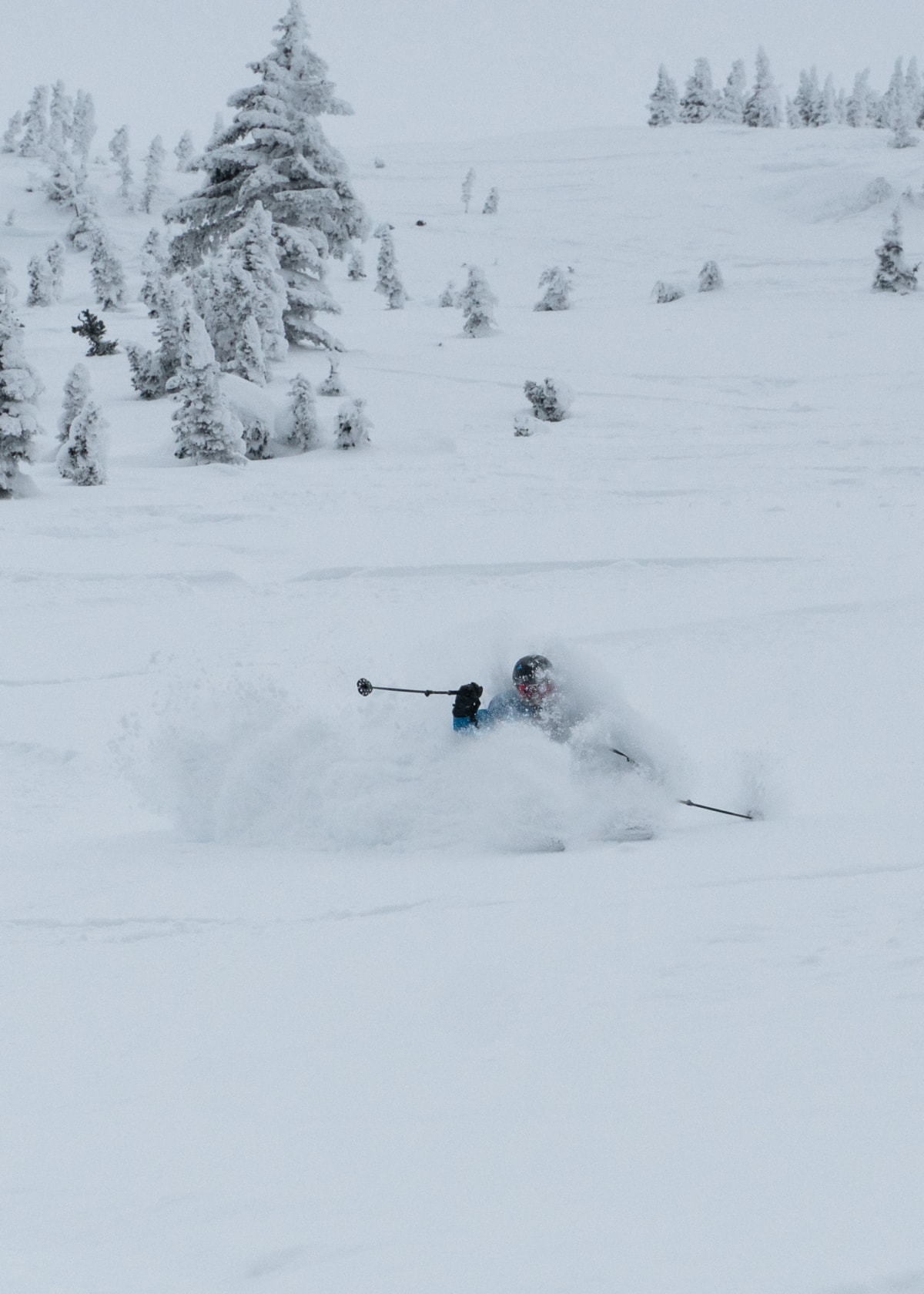 skier slashing a powerful turn in deep powder