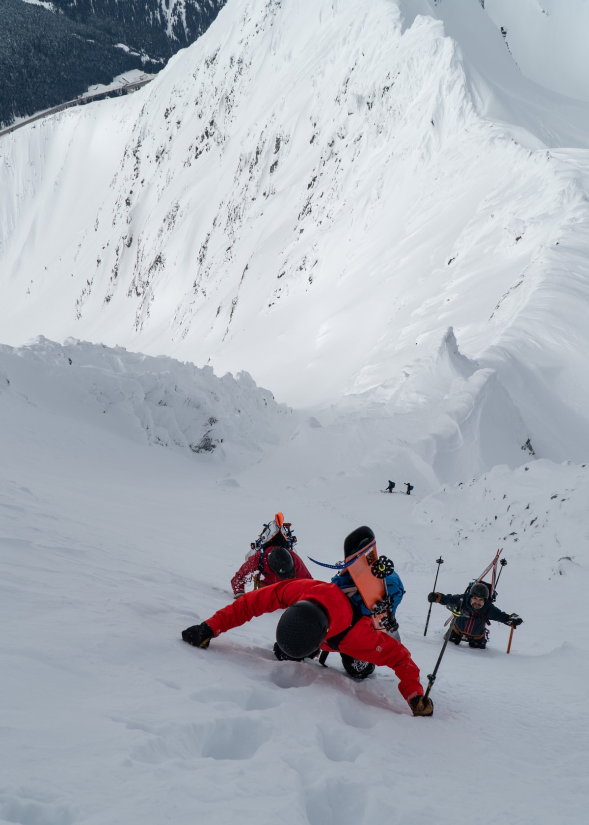 group of skiers booting up a steep snowy slope at rogers pass