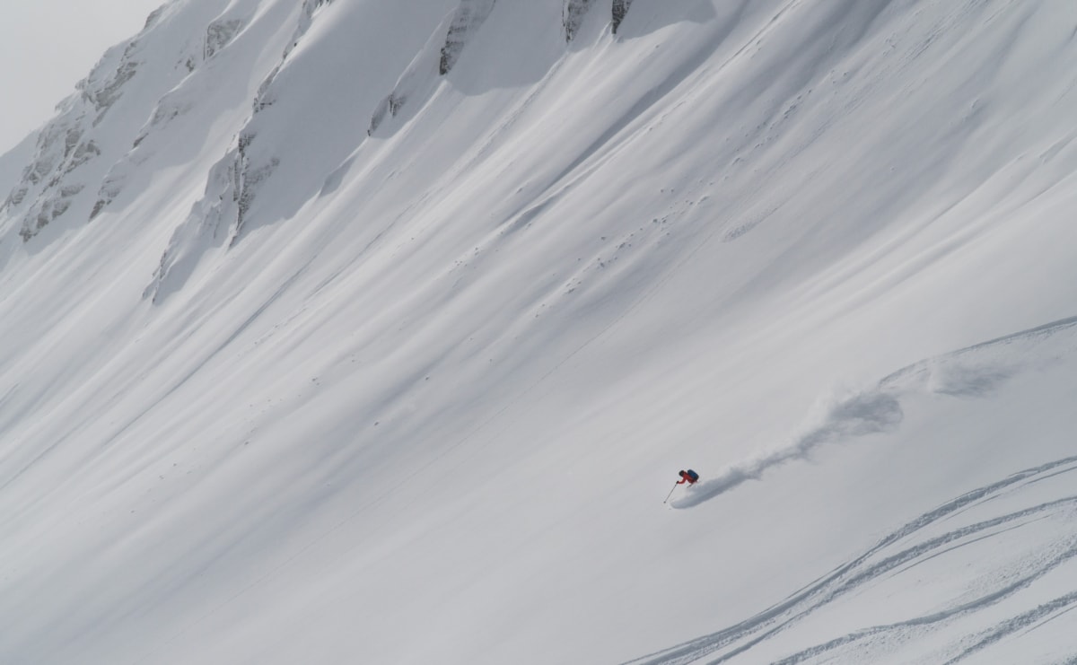 skier carving a fast turn on an alpine face in rogers pass