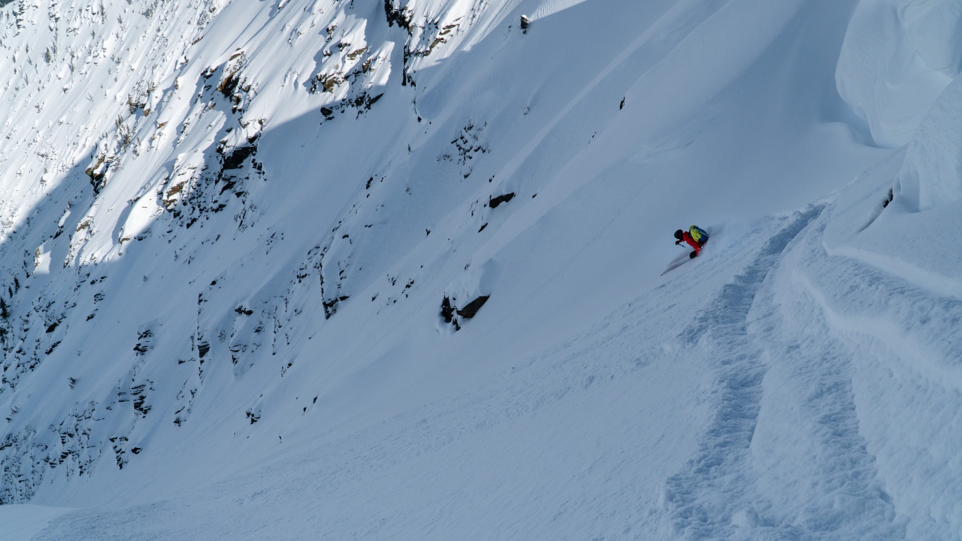 skier carving a turn down a steep couloir in rogers pass