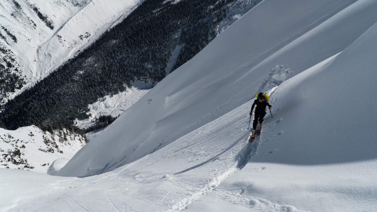 skier touring up a steep exposed slope near ross peak