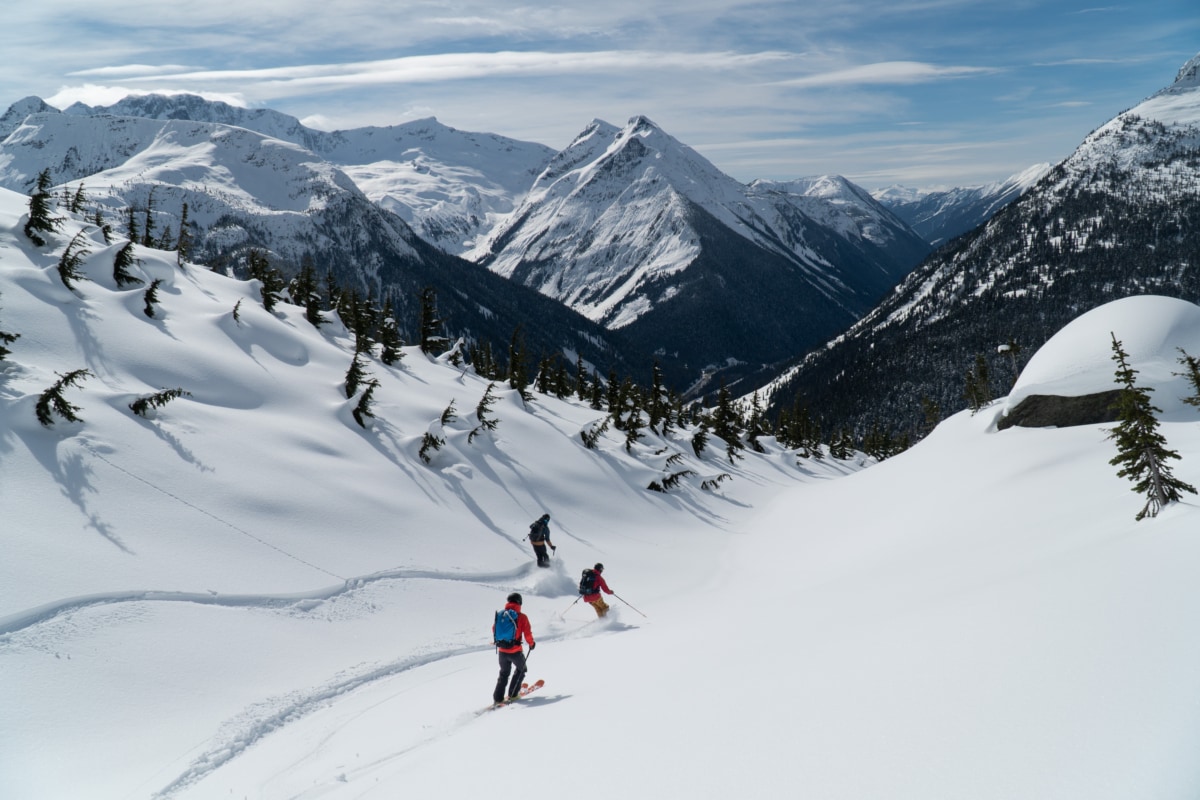 three skiers descending the kors thomas bowl towards avalanche crest