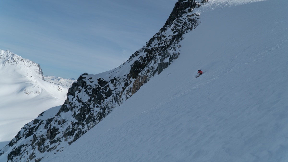 skier carving a steep turn down the thorington route