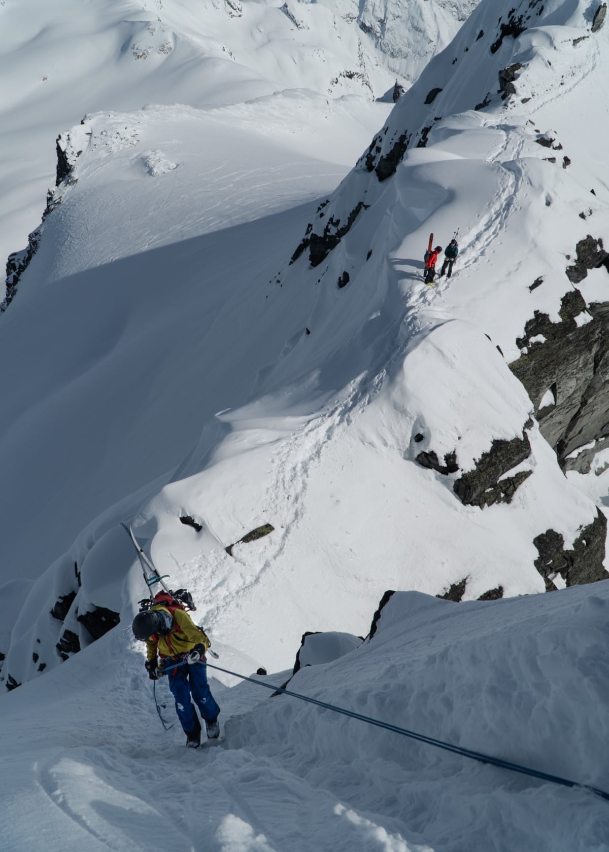 snowboarder rappelling down pollux peak in winter