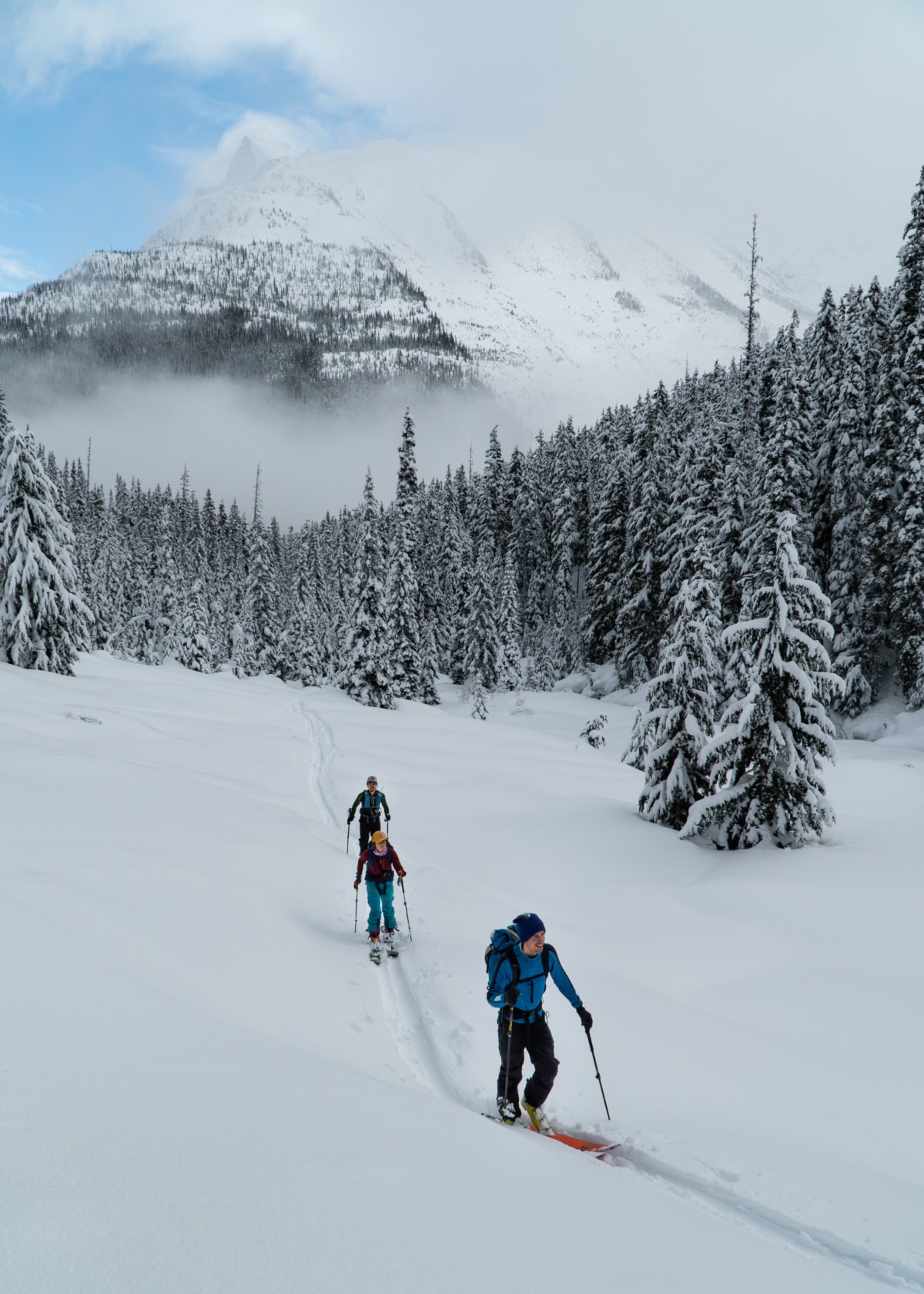 group of skiers crossing connaught creek at rogers pass