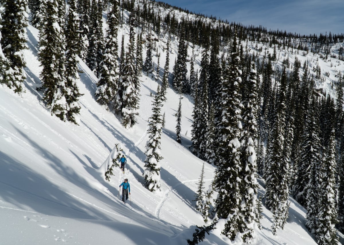 two skiers traversing the south bowl of ursus major mountain