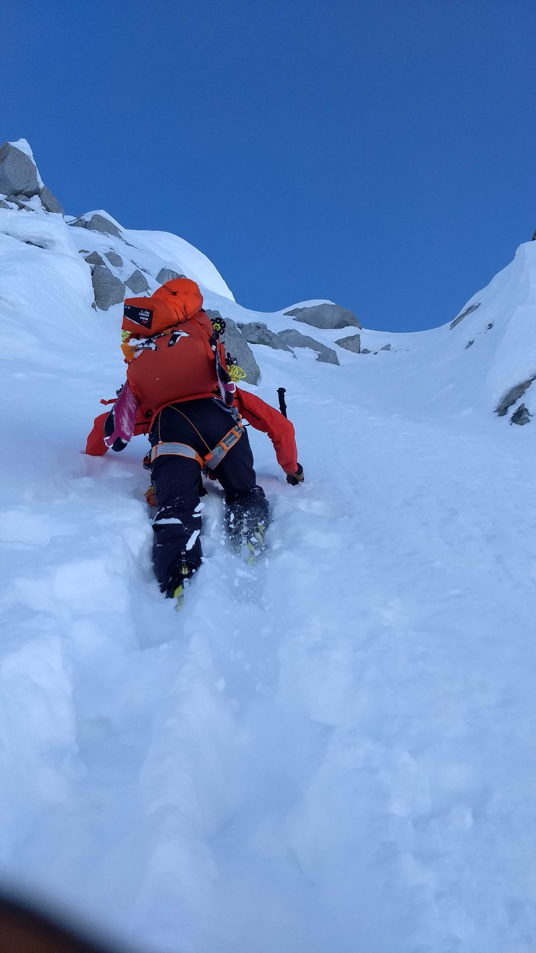 man climbing up a steep snow slope