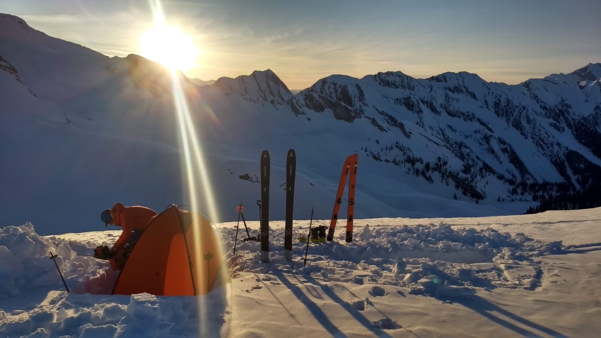 skier setting up camp at laforme col in winter
