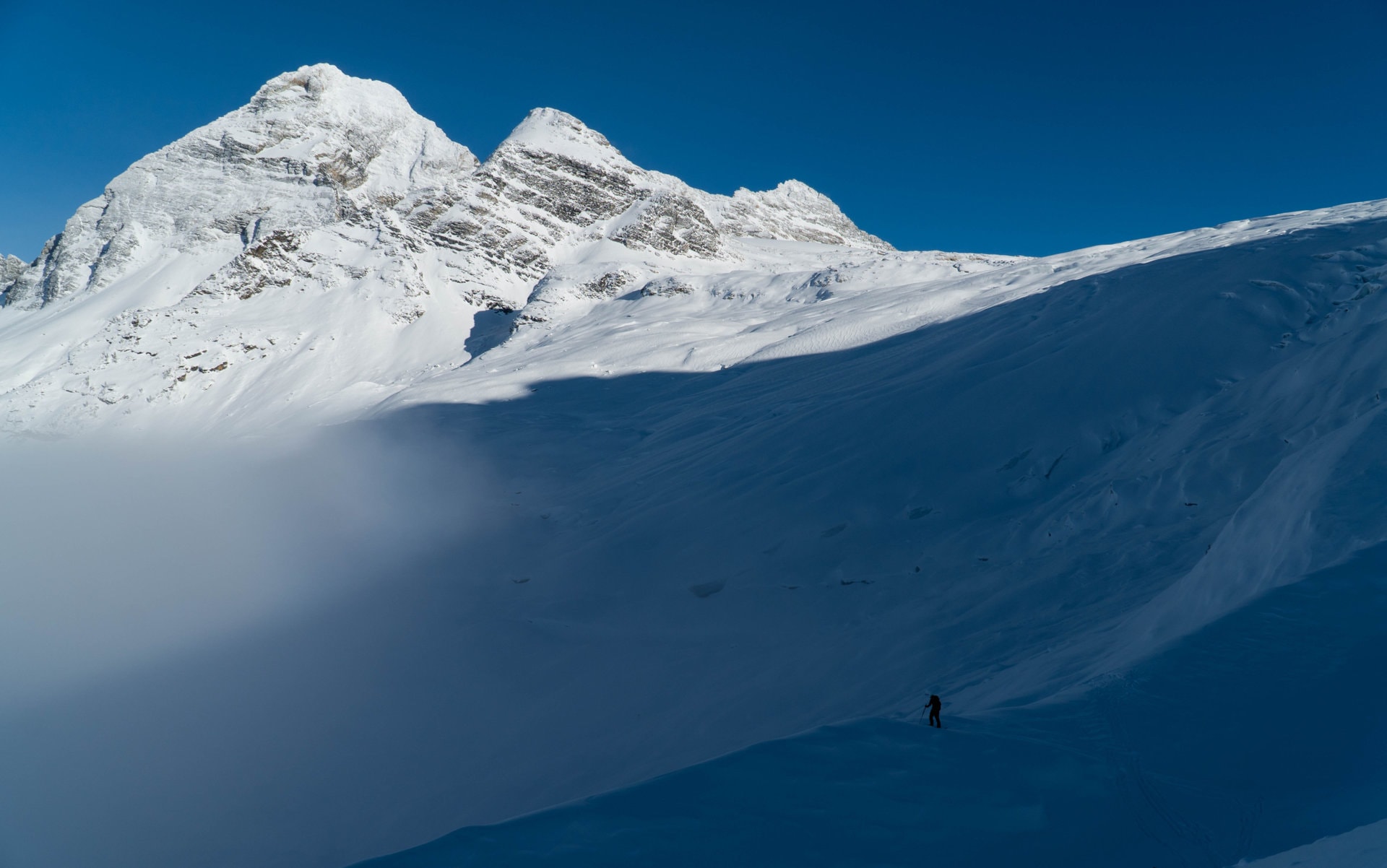 lone skier standing on moraine below lookout col