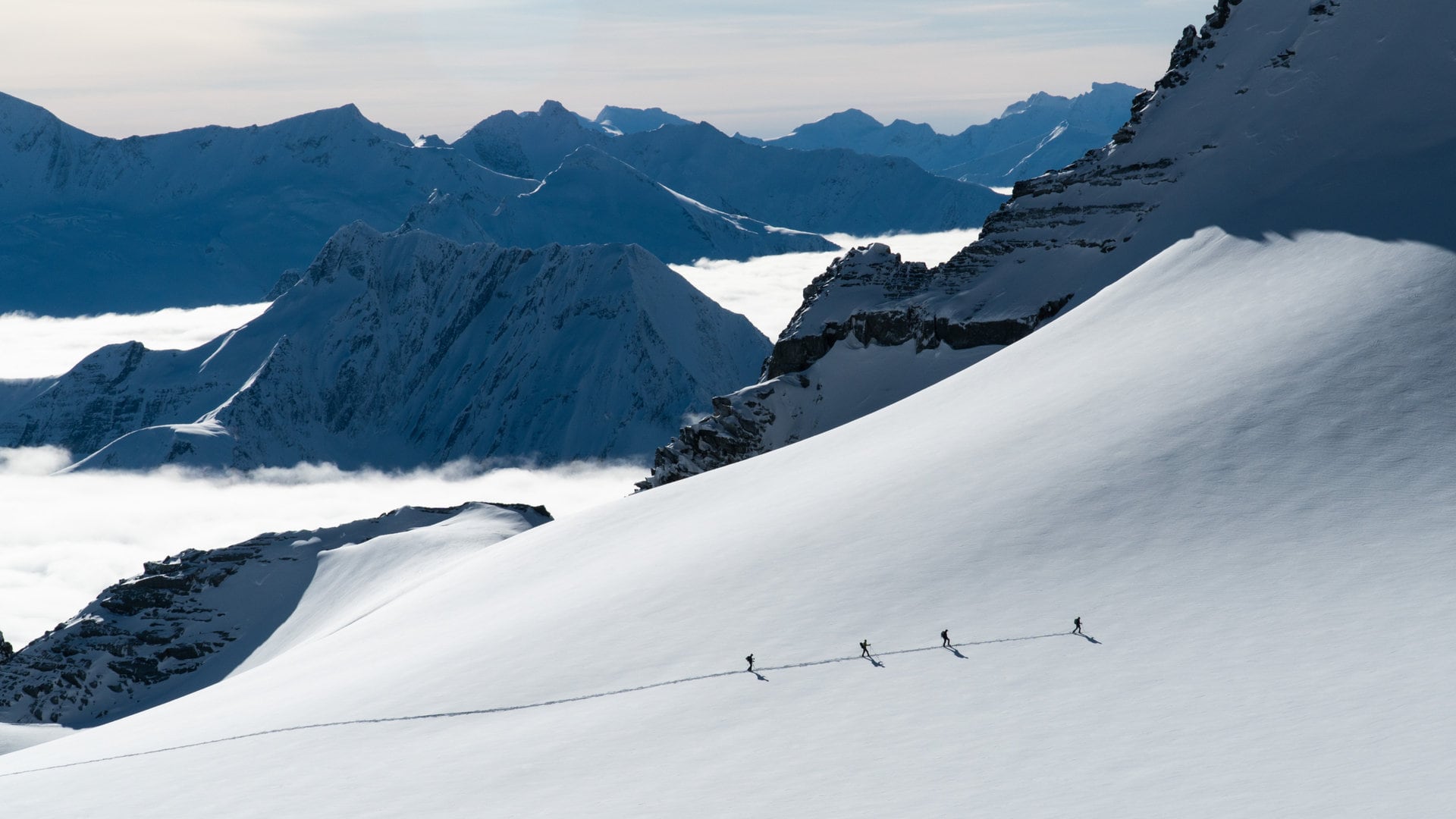 a group of ski tourers crossing the swiss glacier on a rope